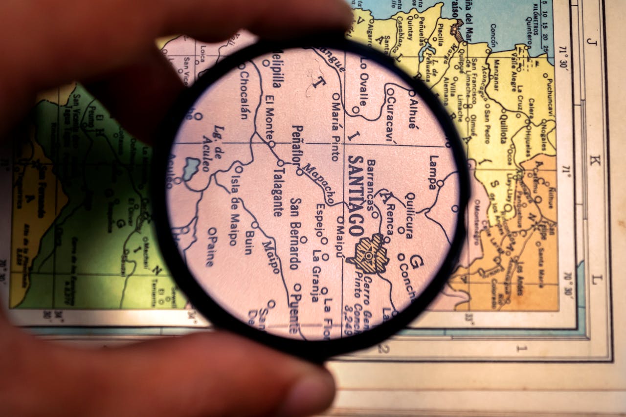 Close-up of a magnifying glass highlighting Santiago on a vintage map of Venezuela.